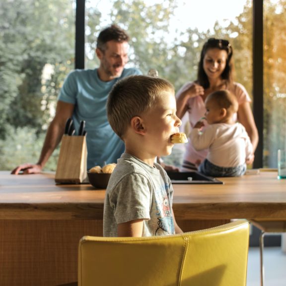 kid-eating-sweets-in-kitchen-with-family-3752857