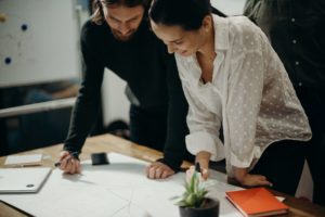 man-and-woman-leaning-on-table-staring-at-white-board-on-top-3205570 (1)