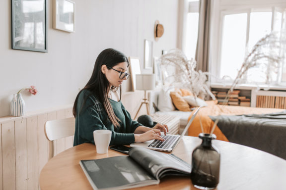 female-freelancer-typing-on-laptop-while-sitting-in-bedroom-4050426