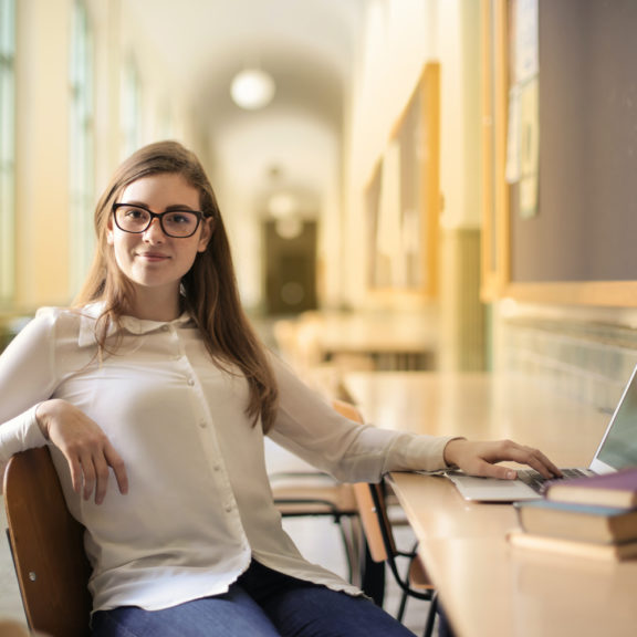 woman-in-white-long-sleeve-shirt-sitting-on-chair-3776201